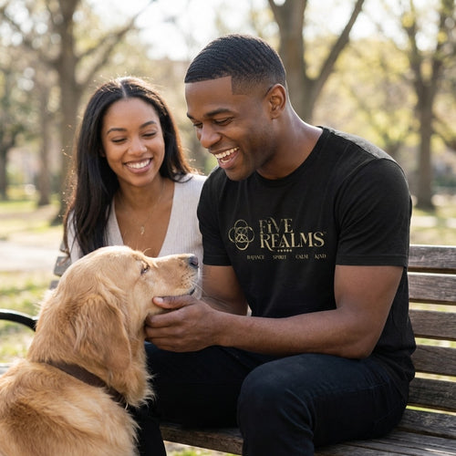Man and woman sitting on a bench with a dog, both smiling