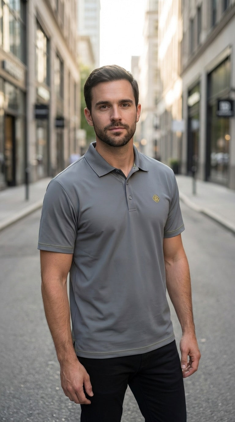 Man wearing a gray polo shirt with a logo on a city street