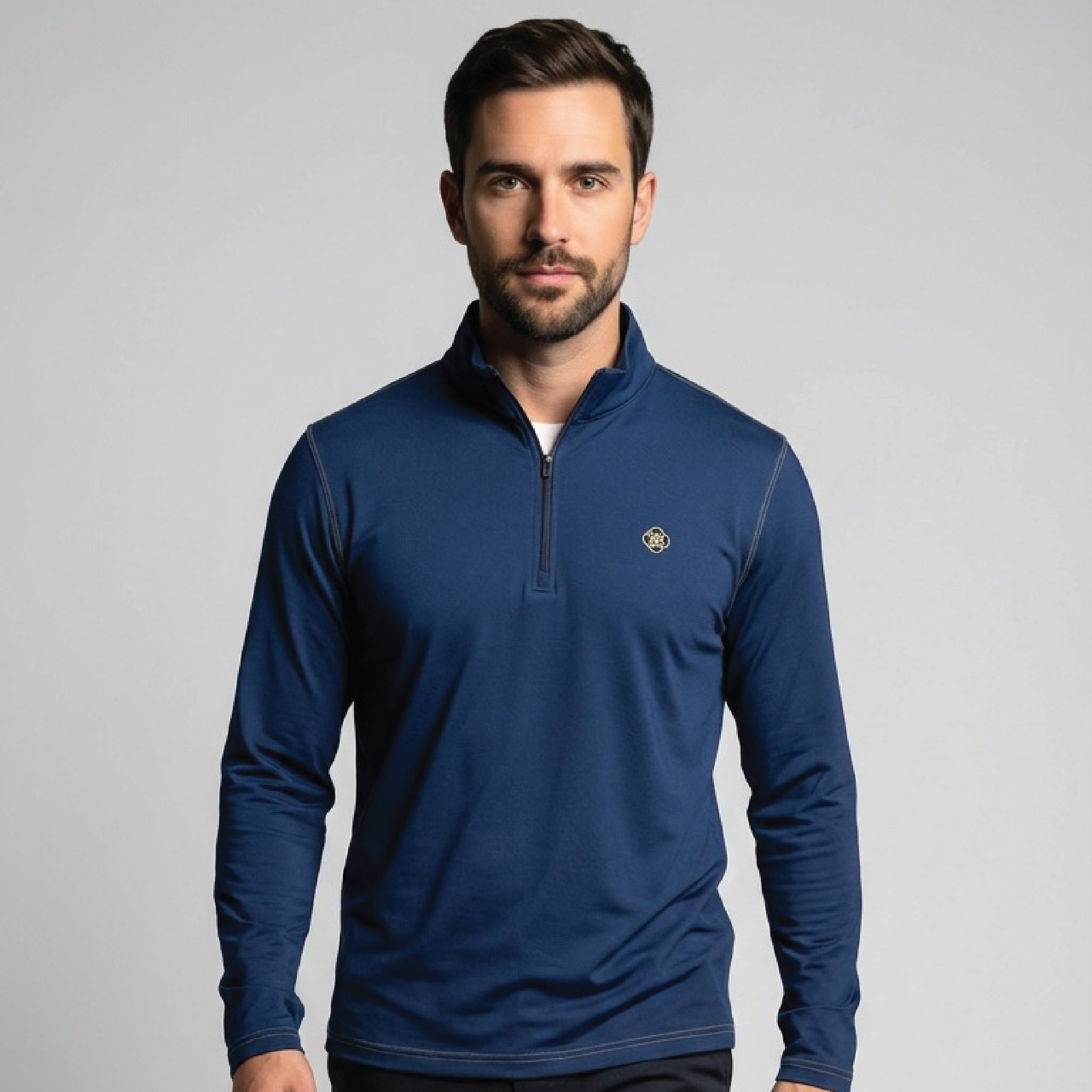 Man wearing a blue pullover with a logo on a gray background
